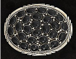 A cluster of 27 black onyx set in a sterling silver oval belt buckle with detailed design around the edge of the buckle. line design going horizontally across the buckle.    Belt loop width measurement: 1.5"